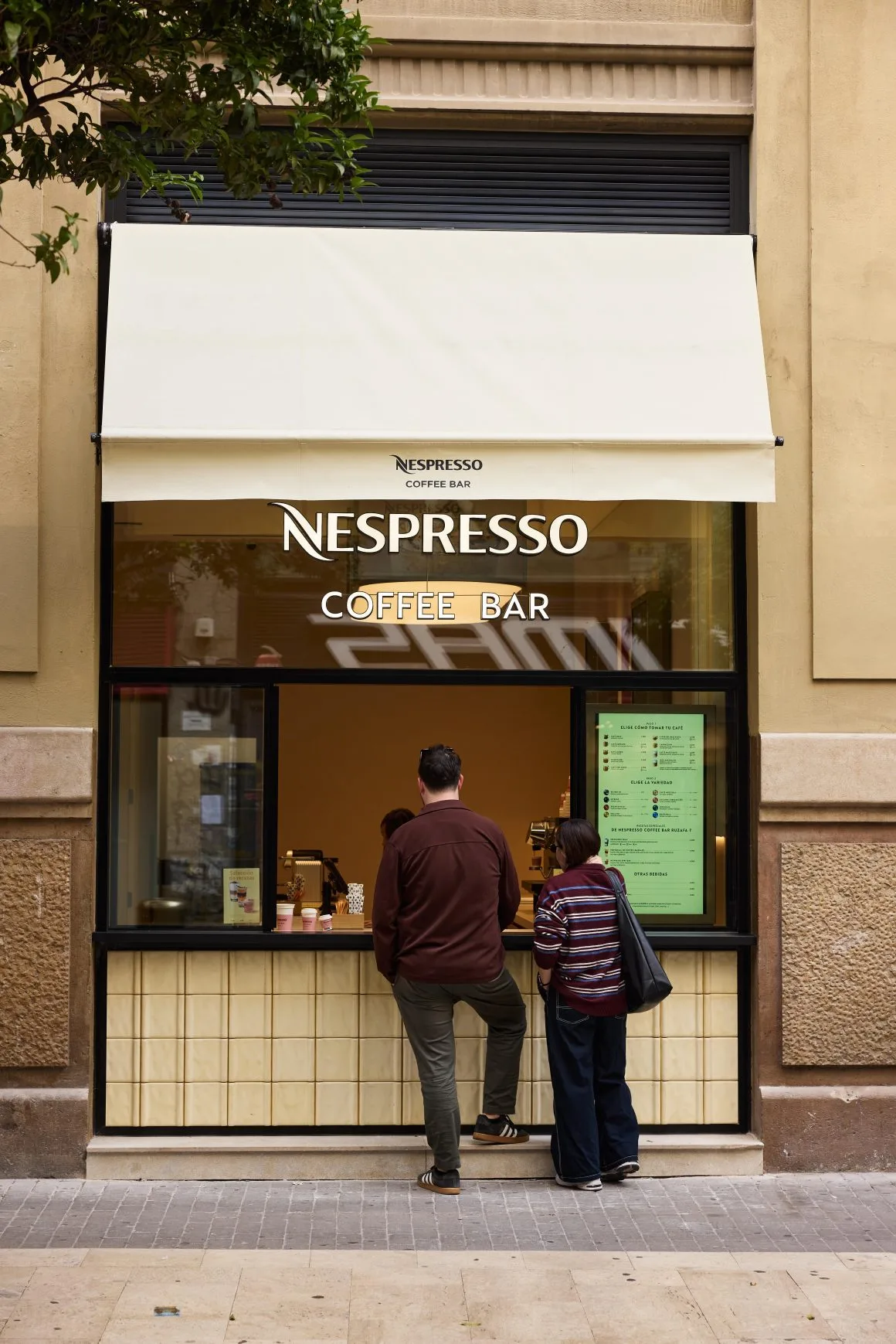 nespresso coffee bar storefront with two customers ordering at the counter., boutique nespresso aqua, valència