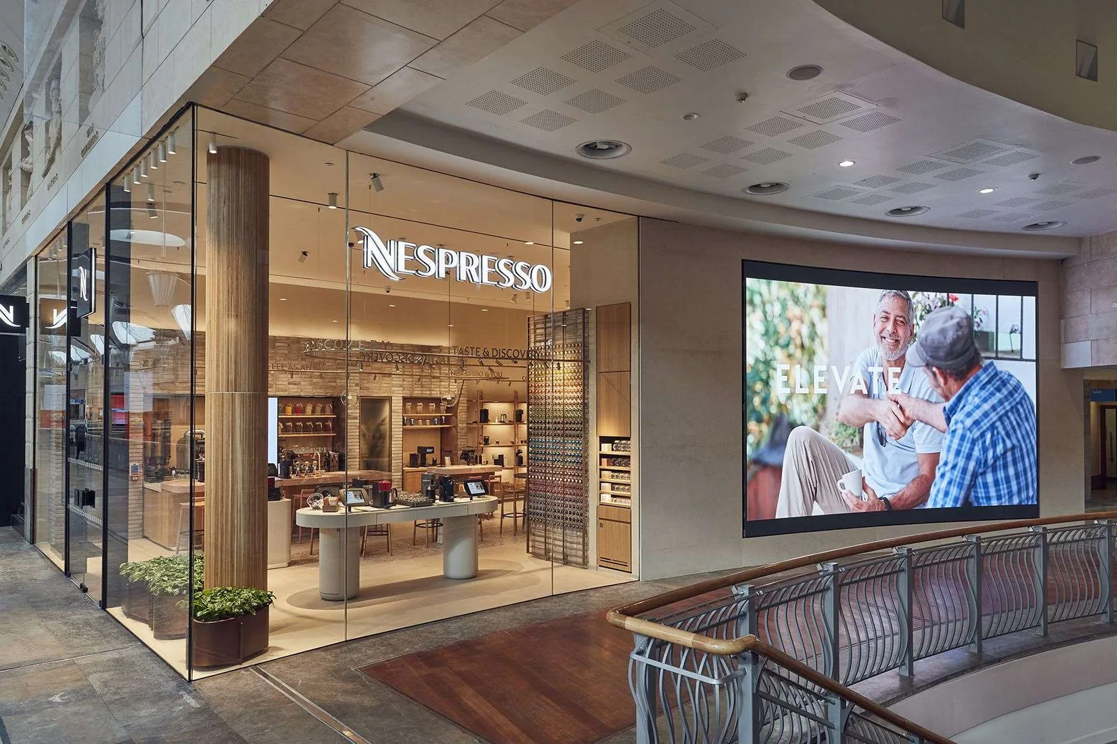 nespresso boutique storefront with warm lighting and product displays in mall corridor., boutique nespresso, arese