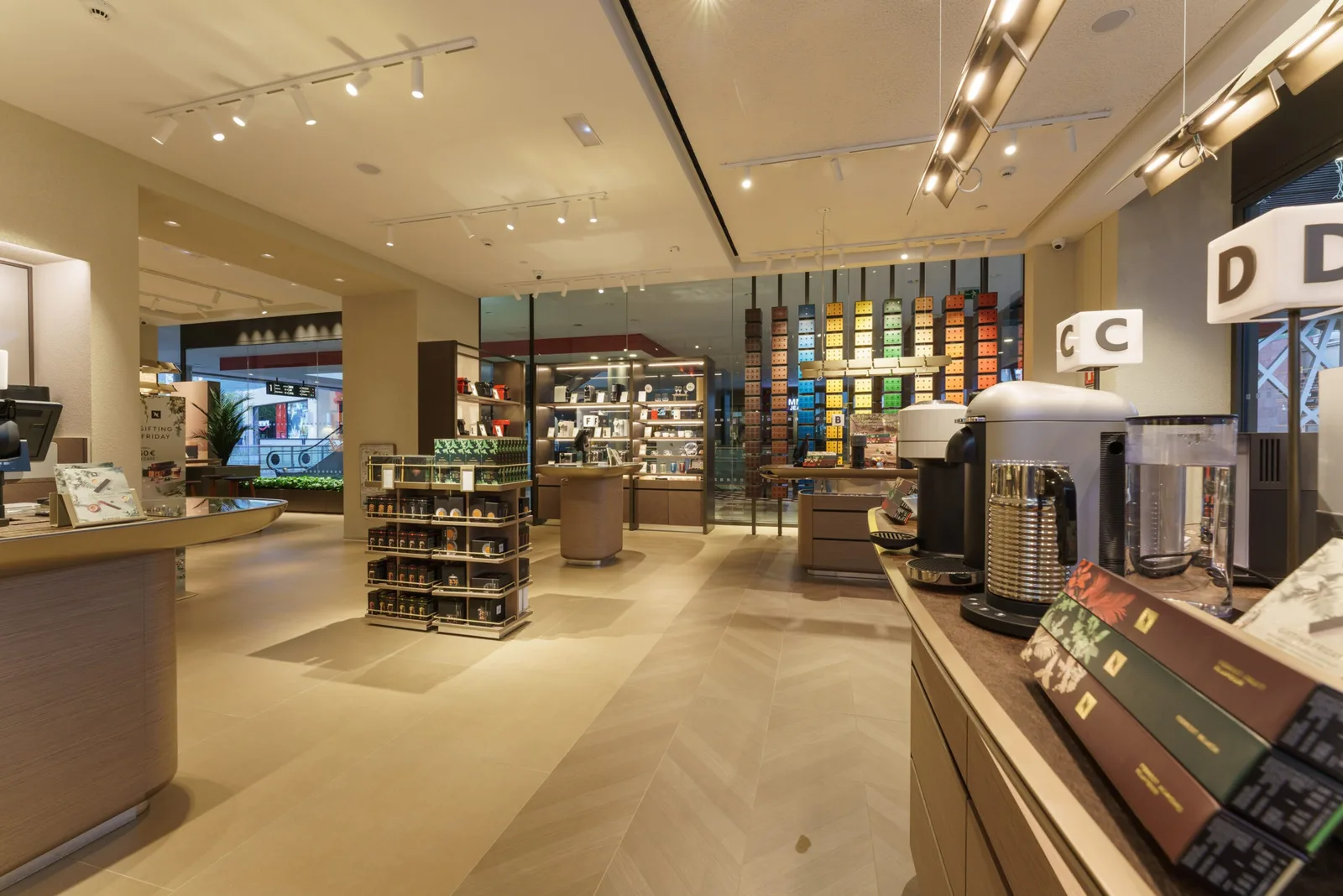 modern retail coffee shop interior with display shelves and beverage equipment., boutique nespresso la maquinista, barcelona