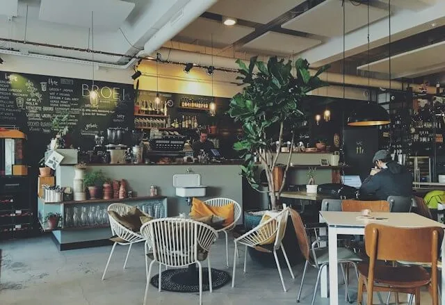 modern café interior with black counter, hanging plants, and contemporary seating arrangements., brass horn coffee roasters, 