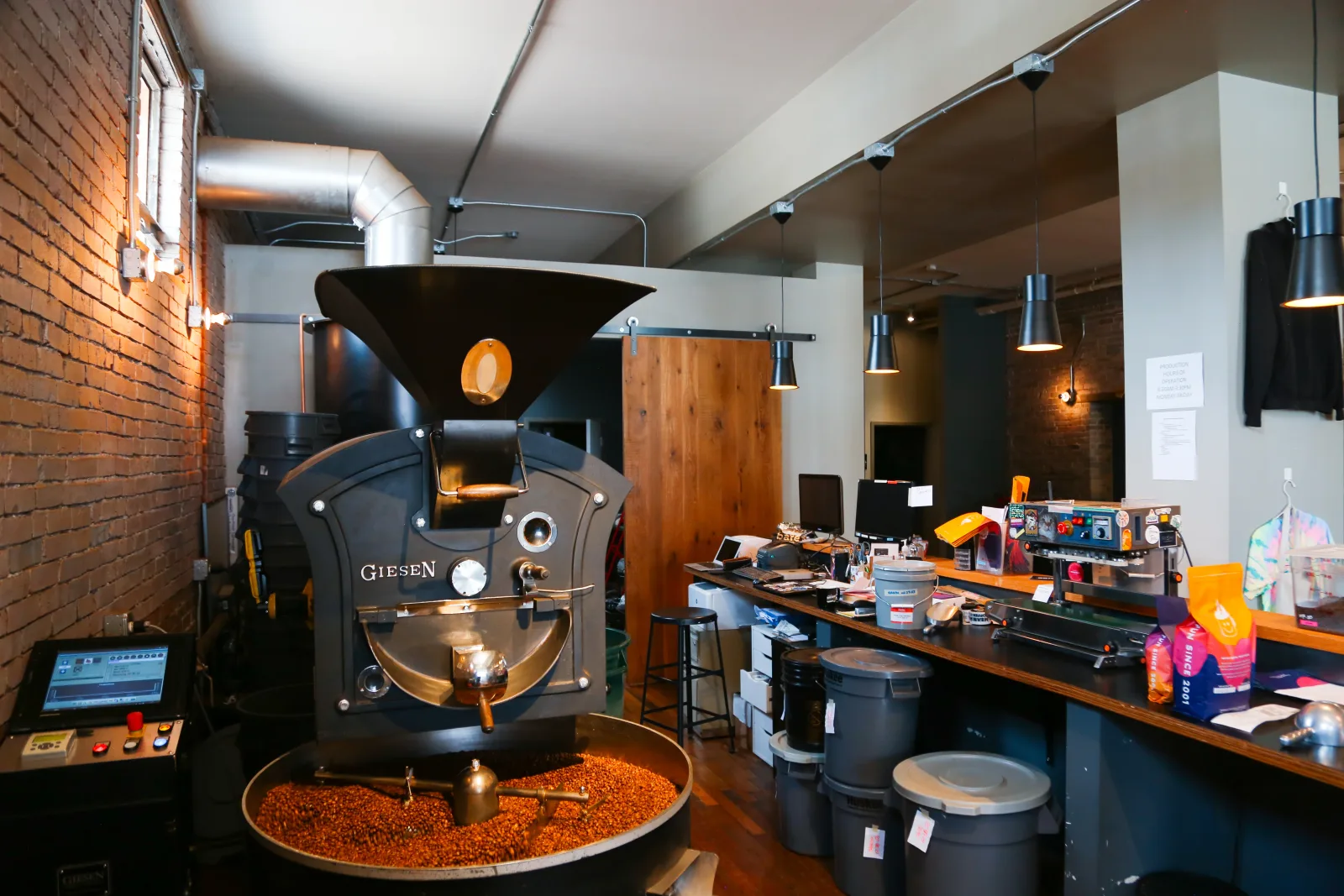 professional coffee roastery with large giesen roaster and processing equipment displayed., brioso roastery & coffee bar, col