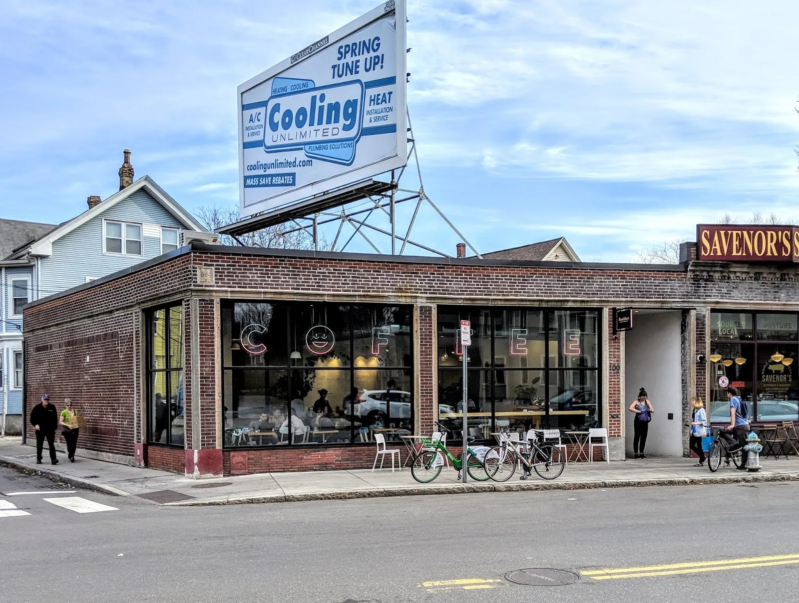 brick storefront café with large windows, bicycles parked outside, residential neighborhood setting., broadsheet coffee roast