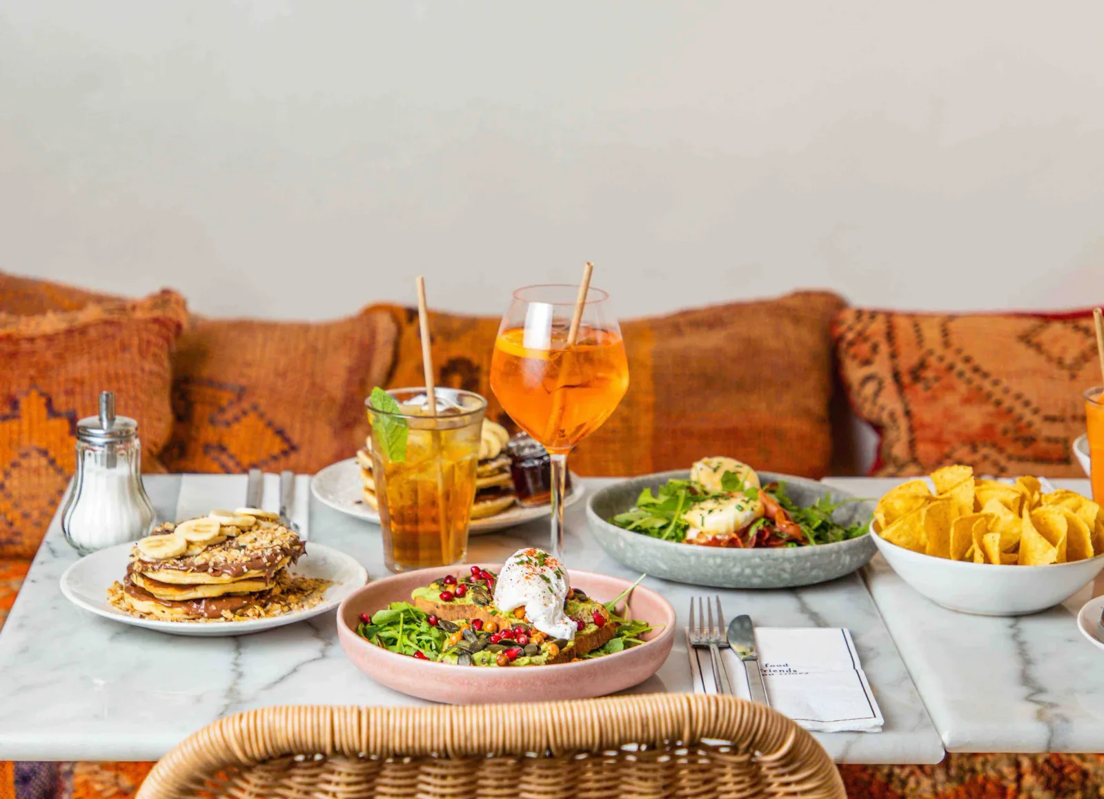 brunch spread with pancakes, salads, chips, and colorful beverages on marble table., brother sister brunch lunch dinner, pari