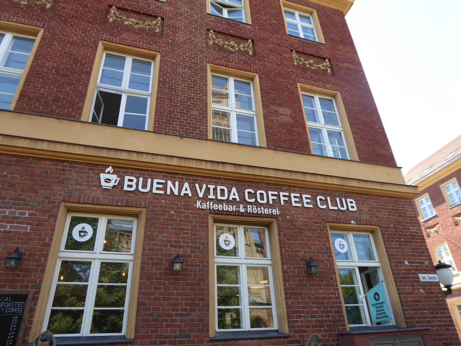 red brick building with "buenavida coffee club" storefront and multiple windows., buena vida coffee roasters, potsdam