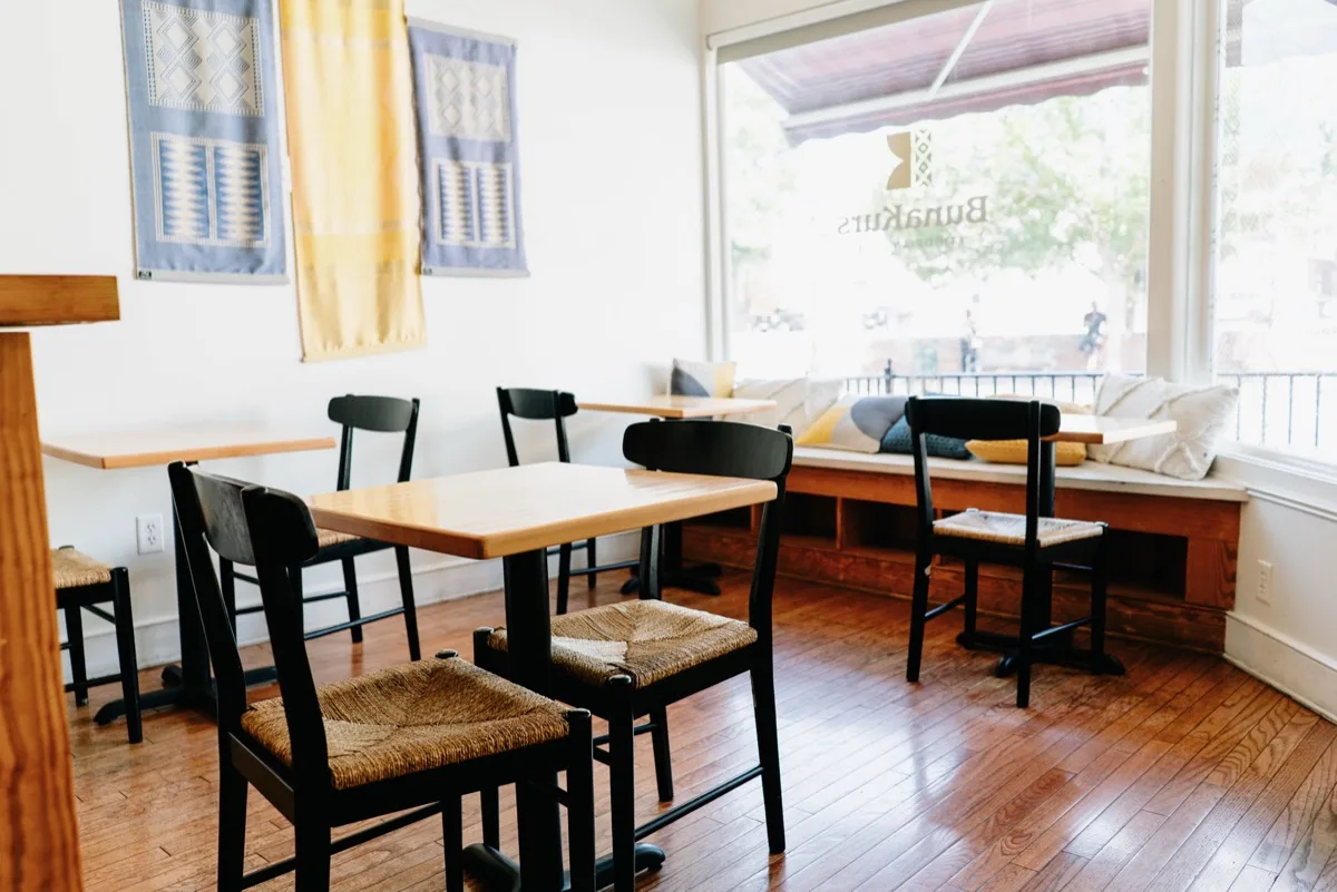 bright dining space with wooden tables, black chairs, and large windows overlooking waterfront., bunakurs, richmond