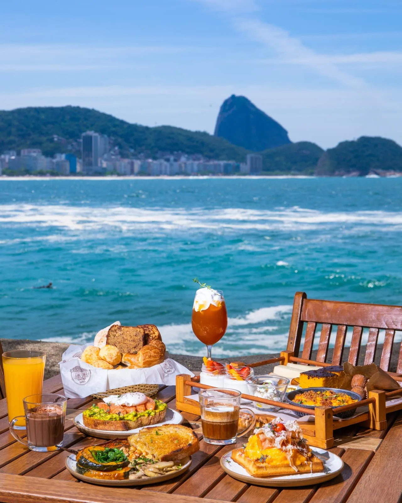 beach brunch spread with ocean view and iconic mountain backdrop., café 18 do forte, rio de janeiro