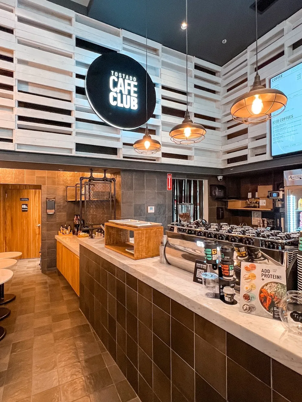 tostado cafe club interior with counter, espresso machine, and pendant lighting., cafe club, miami
