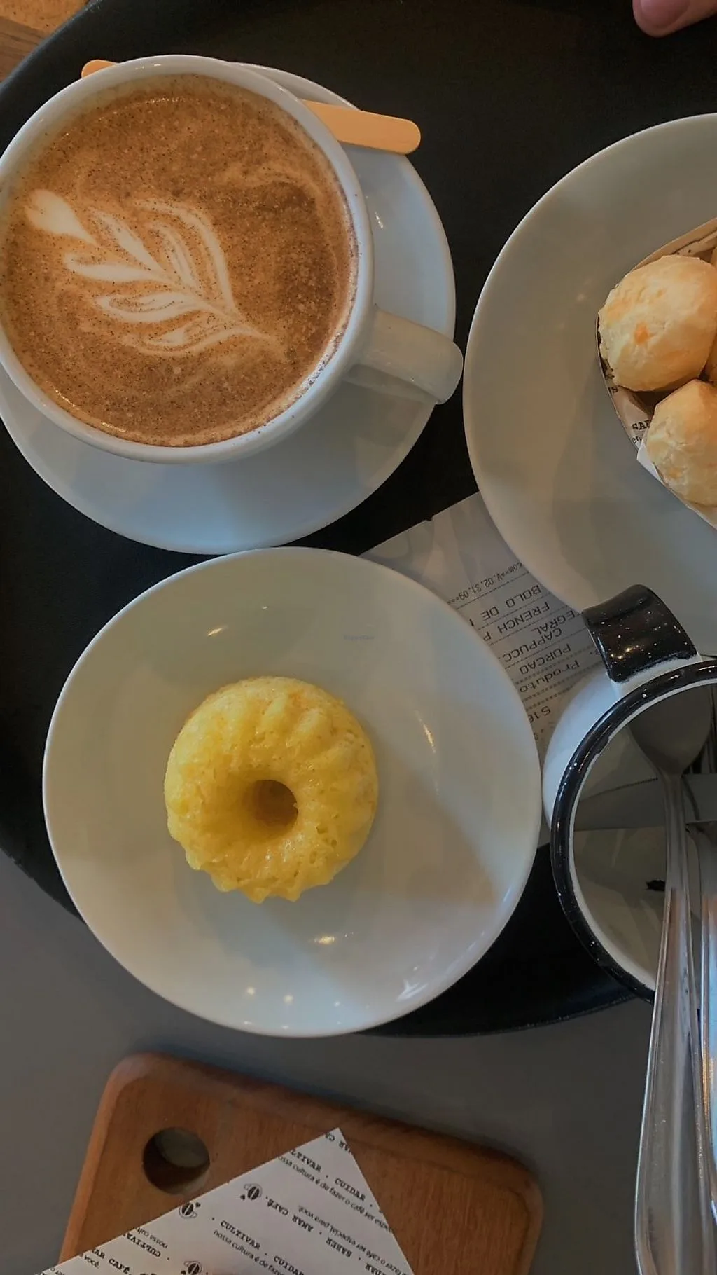 cappuccino with latte art, glazed doughnut, and pastries on table., café cultura, curitiba