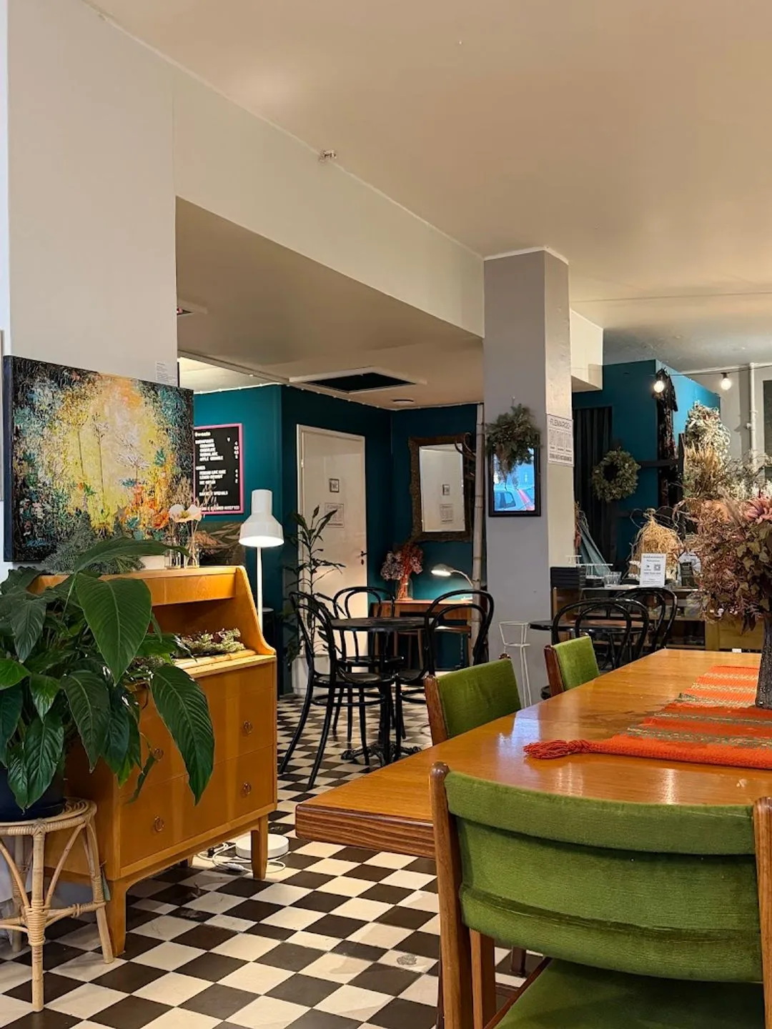 mid-century modern interior with teal walls, checkered floor, and vintage furnishings., cafe flemari20, helsinki