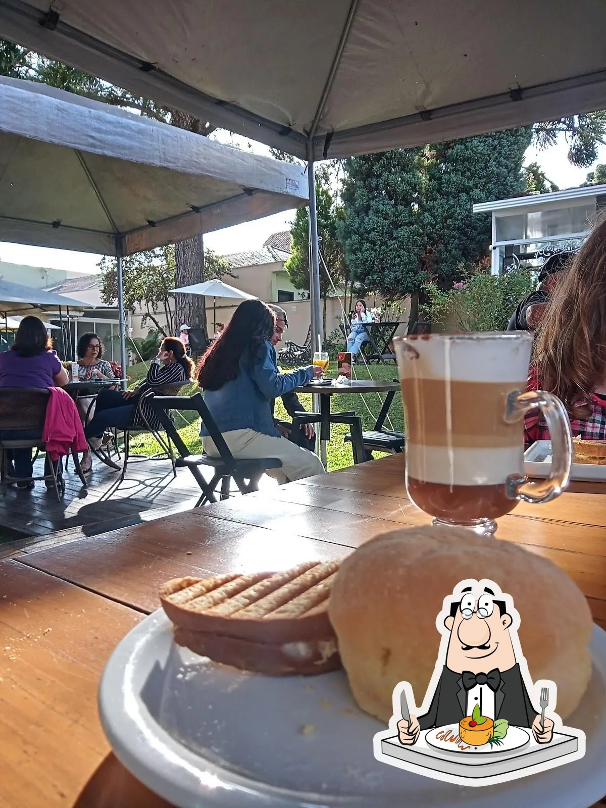outdoor garden gathering with bread, beverage, and dining under tent shade., café flor de laranjeira, curitiba