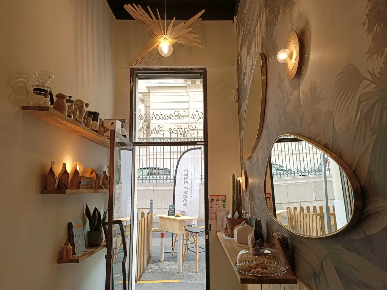 warm interior space with wooden shelves, mirrors, pendant lights, and open storefront view., café lauca « la boutchica », mar