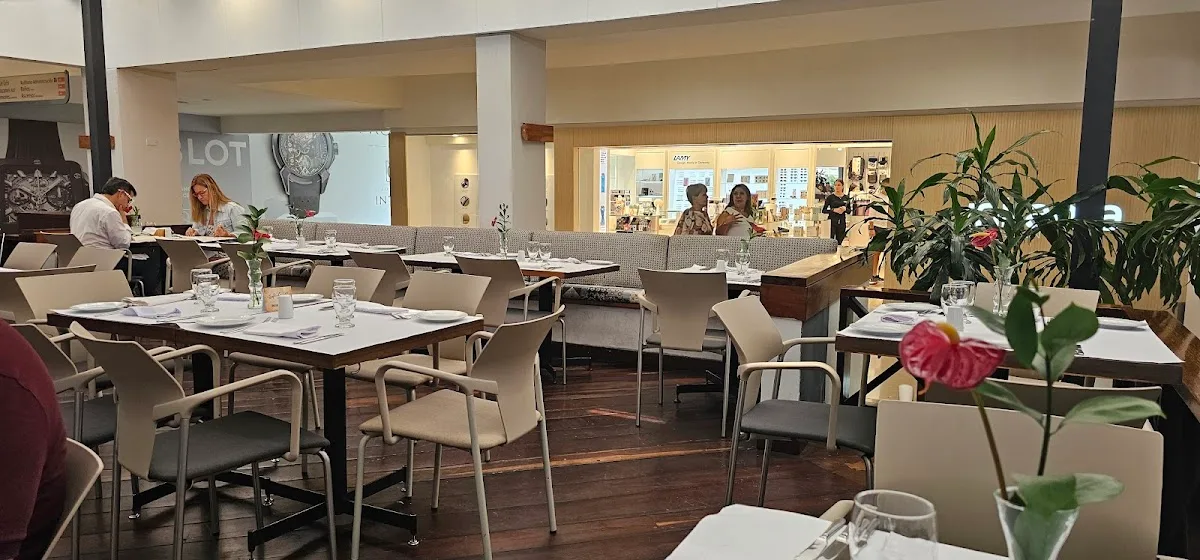 modern restaurant dining room with tables, chairs, plants, and diners throughout space., café le gris, medellín