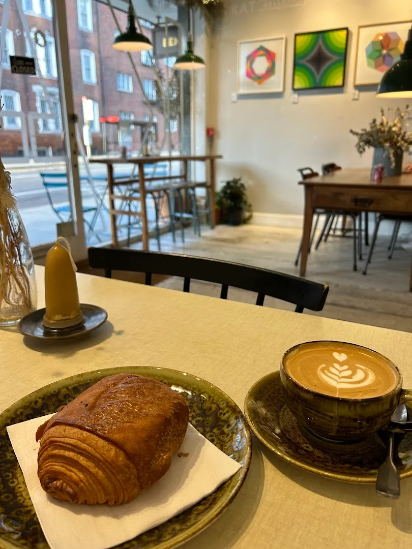 croissant and latte with latte art in modern café interior with street view., cafe nos: specialty coffee & craft bakery, bogo