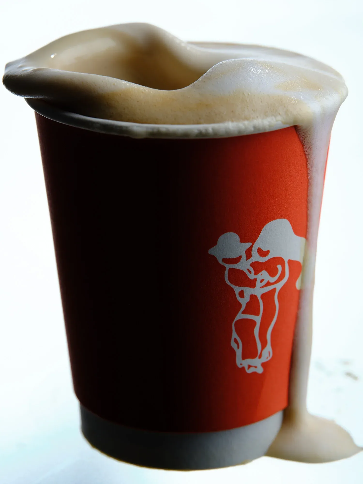 dark beer with creamy foam head in red and black branded cup., café nuances - vendôme, paris