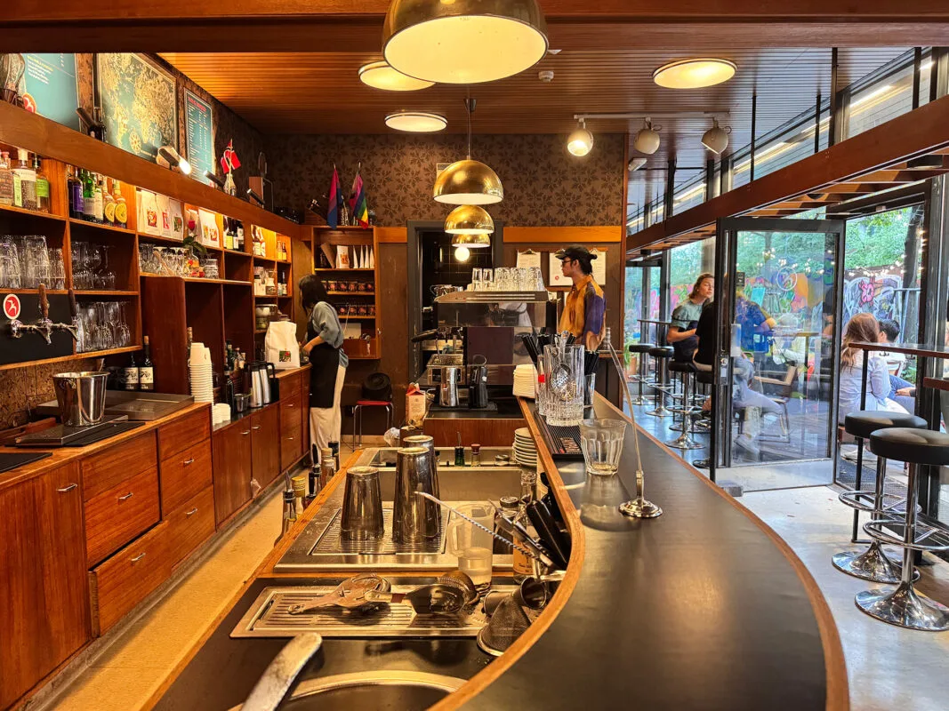 modern coffee shop with curved counter, wooden cabinetry, and pendant lighting., =cafe, oslo