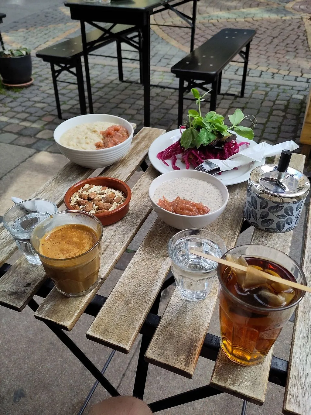 outdoor café table with various dishes, beverages, and fresh ingredients on wooden surface., café sonja, copenhagen
