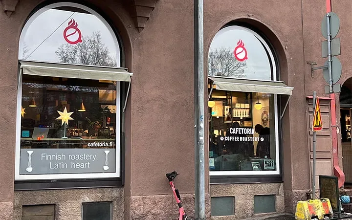 finnish coffee roastery storefront with arched windows and latin heart branding., cafetoria café & shop, helsinki
