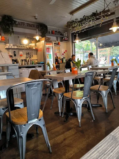 bright café interior with metal chairs, wooden tables, and counter service area., caffe paola, london