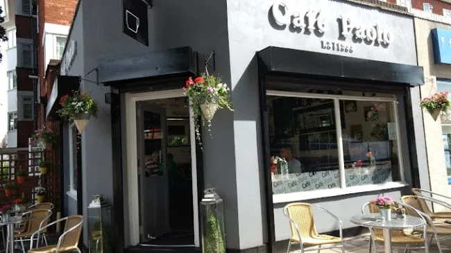 chic storefront with black awning, hanging baskets, and outdoor seating area., caffe paola, london