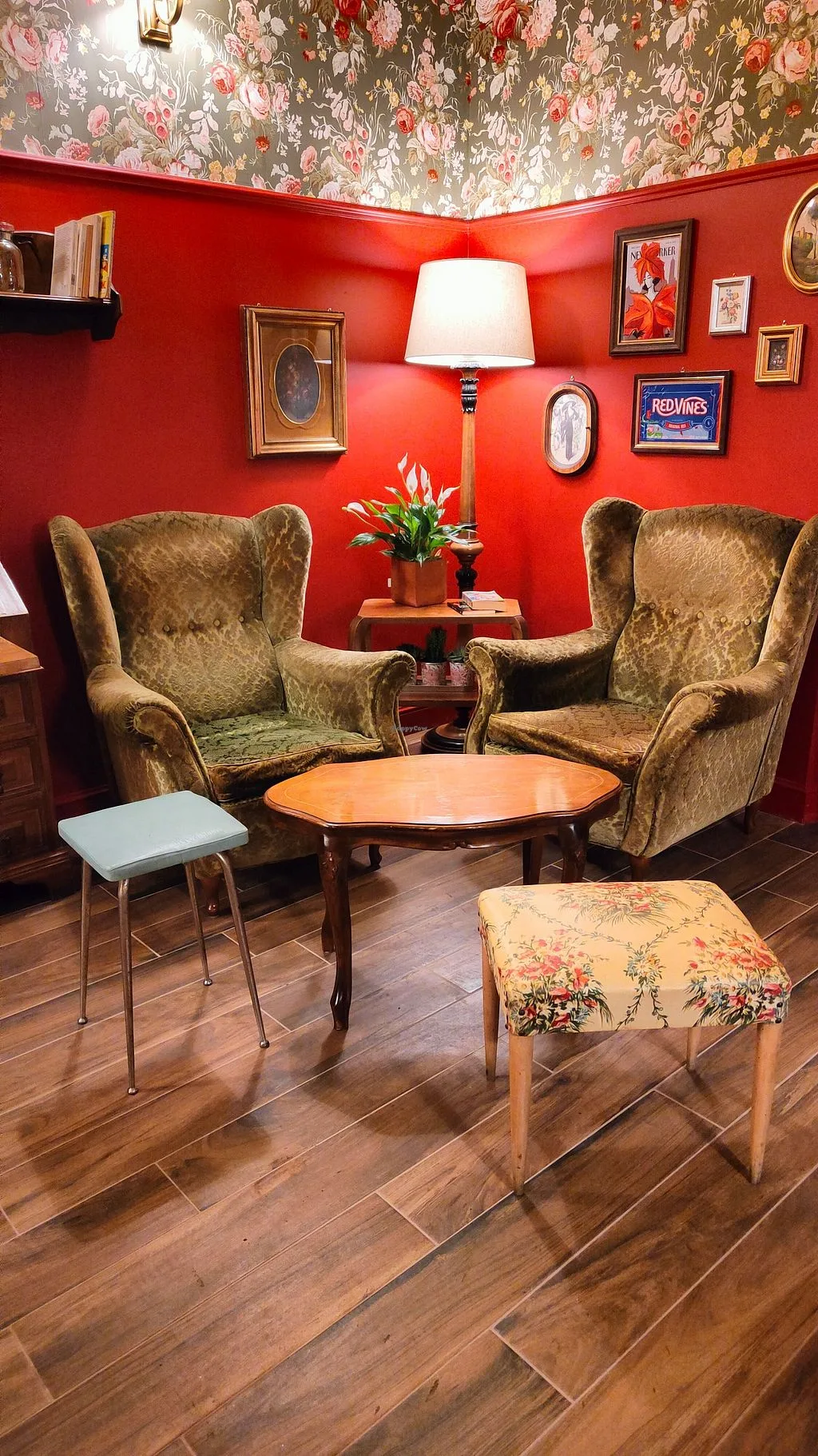 red walls with floral wallpaper ceiling, vintage wingback chairs, round table, lamp., caffetteria snug the comfort café, rome
