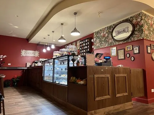 red-walled café interior with dark wood counter and pendant lighting., caffetteria snug the comfort café, rome