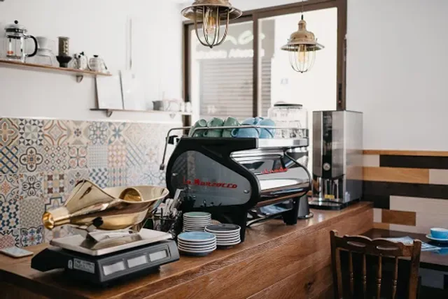 modern kitchen counter with espresso machine, grinder, and decorative patterned backsplash tiles., camden coffee roasters (ve