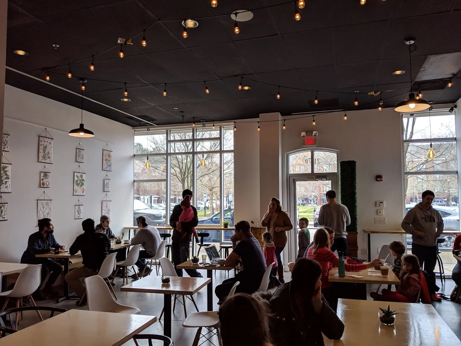 modern café interior with patrons dining, pendant lighting, and street-facing windows., canvas coffee, newport news