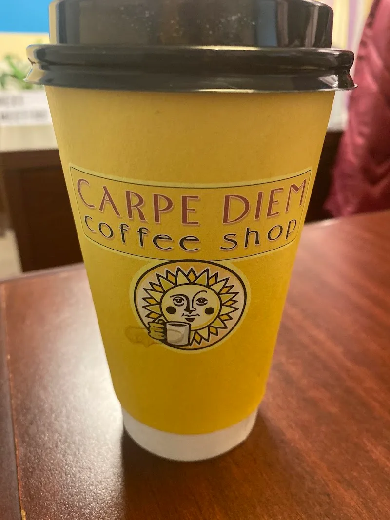 yellow coffee cup from carpe diem coffee shop with sun logo and black lid., carpe diem coffee shop, ohio