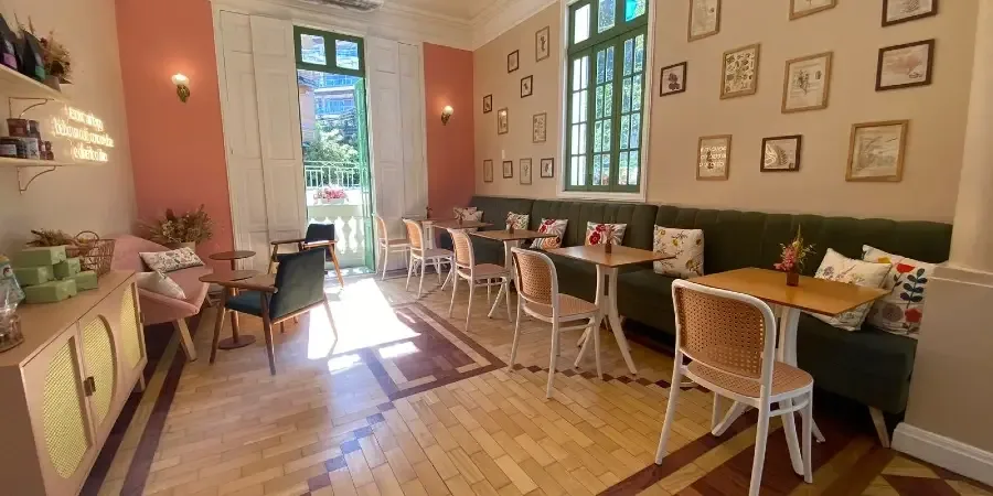 charming café interior with coral accent wall, booth seating, and natural light., casa que doce, rio de janeiro