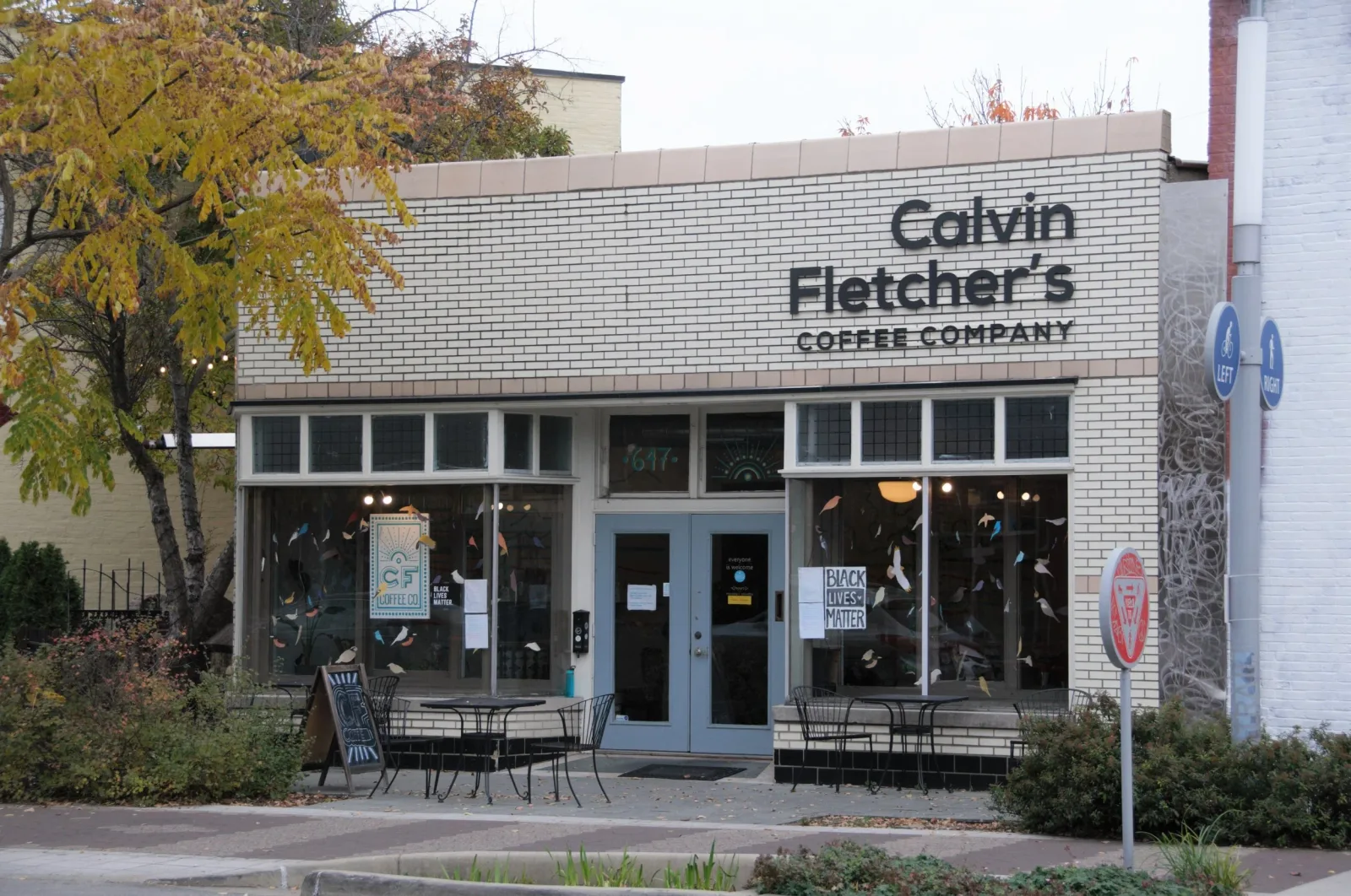 calvin fletcher's coffee company storefront with white brick facade and blue entrance doors., cf coffee company, indianapolis