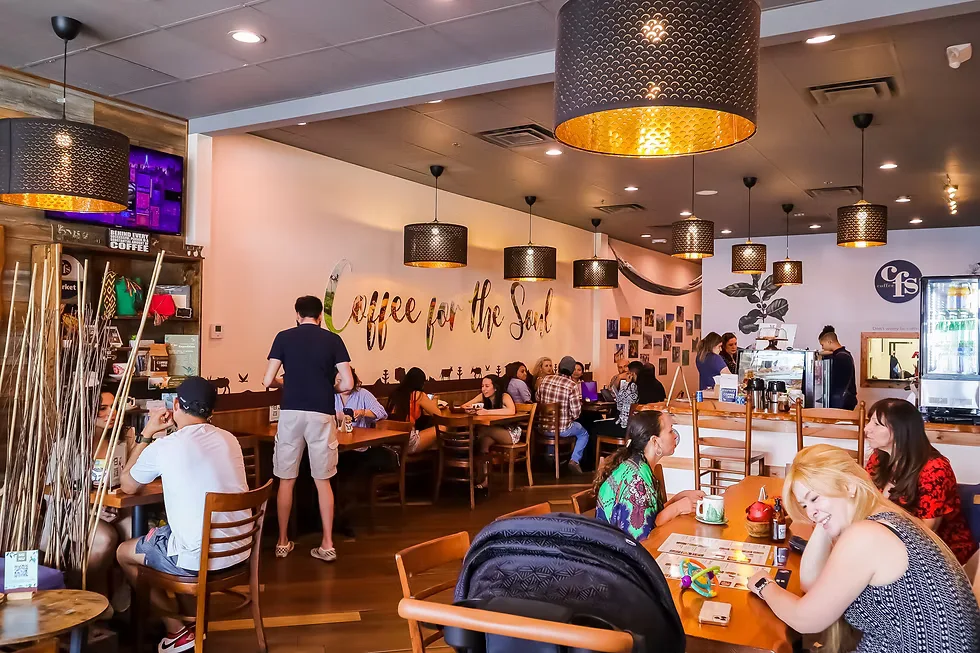 cozy coffee shop interior with customers seated at wooden tables under decorative pendant lights., cfs coffee oviedo, orlando