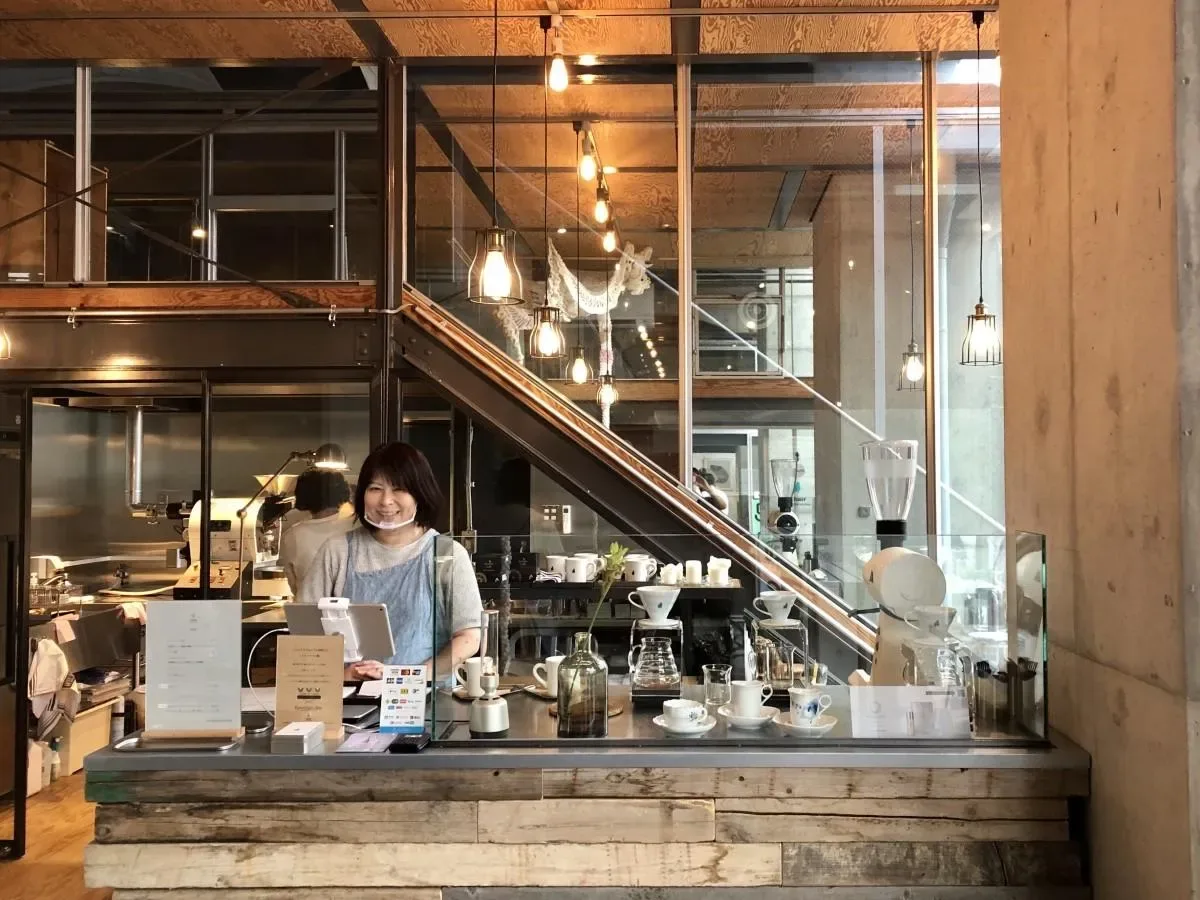 modern coffee shop interior with barista at counter and industrial design elements., chair coffee roasters, yokohama