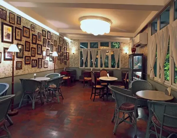 eclectic café interior with framed gallery wall, wooden furniture, and multiple seating areas., chamiers cafe, chennai