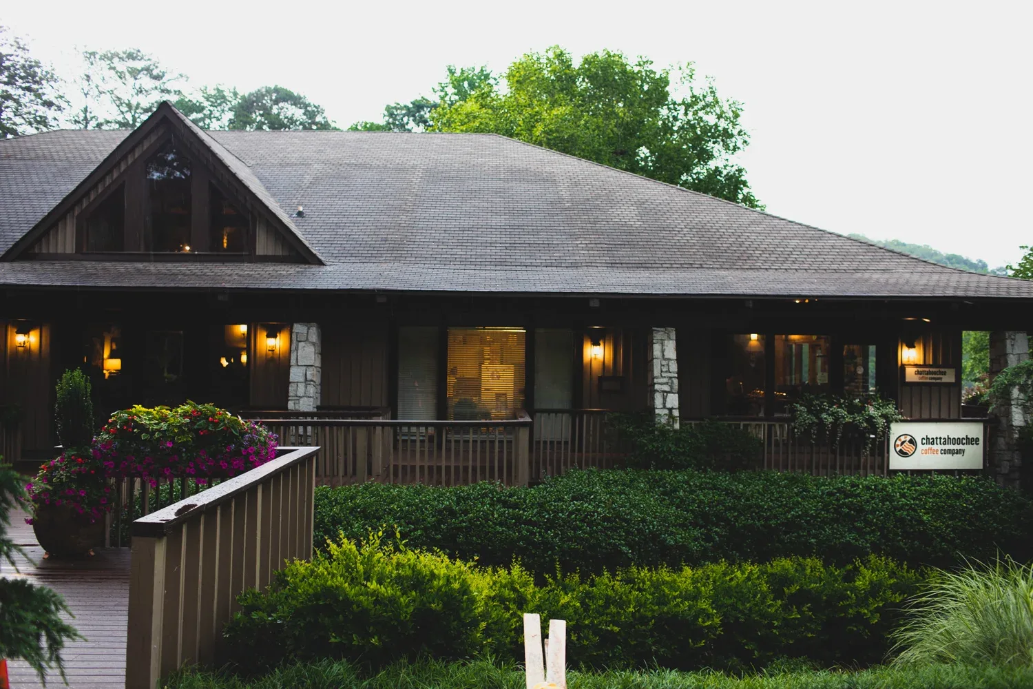 modern dark building with pitched roof, lit windows, and landscaped grounds., chattanooga coffee company, chattanooga