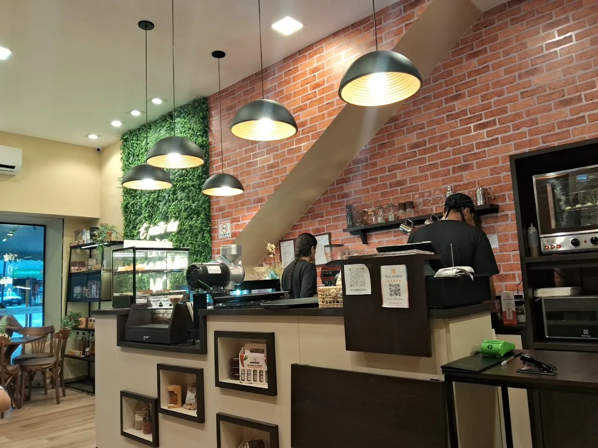 modern coffee shop interior with brick wall, pendant lights, and staff behind counter., cheirin bão, niterói