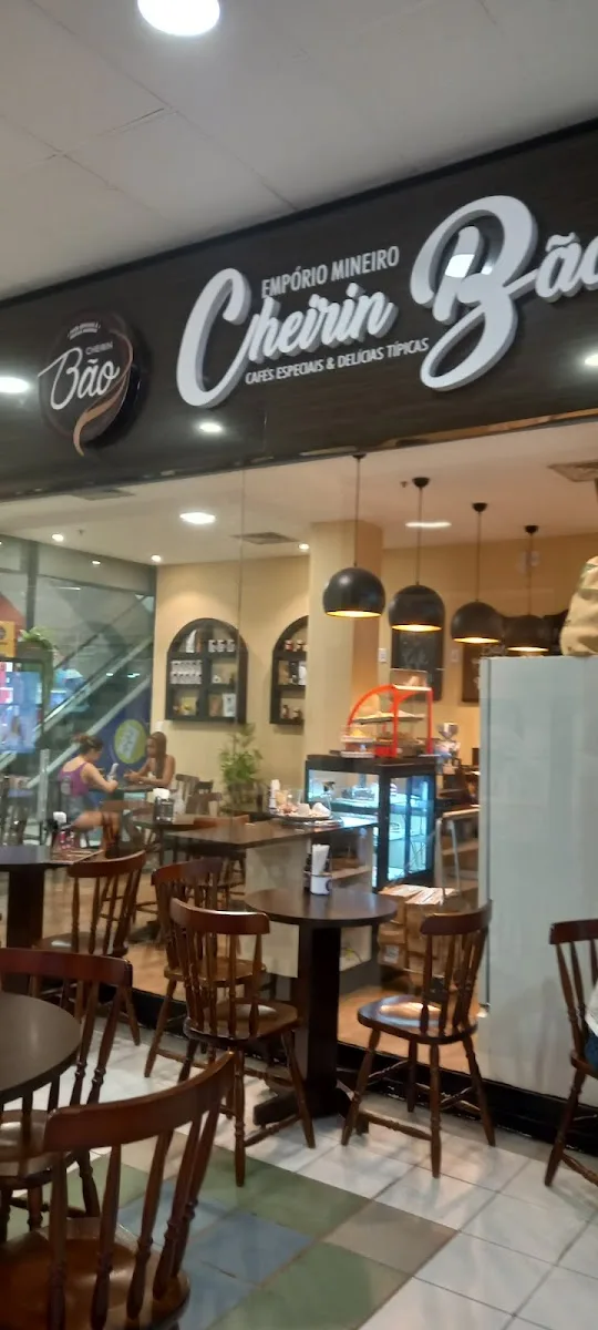 café storefront with wooden tables, chairs, and hanging pendant lights inside establishment., cheirin bão, rio de janeiro