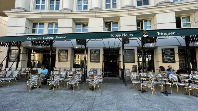 street-level restaurants with striped chairs and black awnings along european plaza., choubidou, paris
