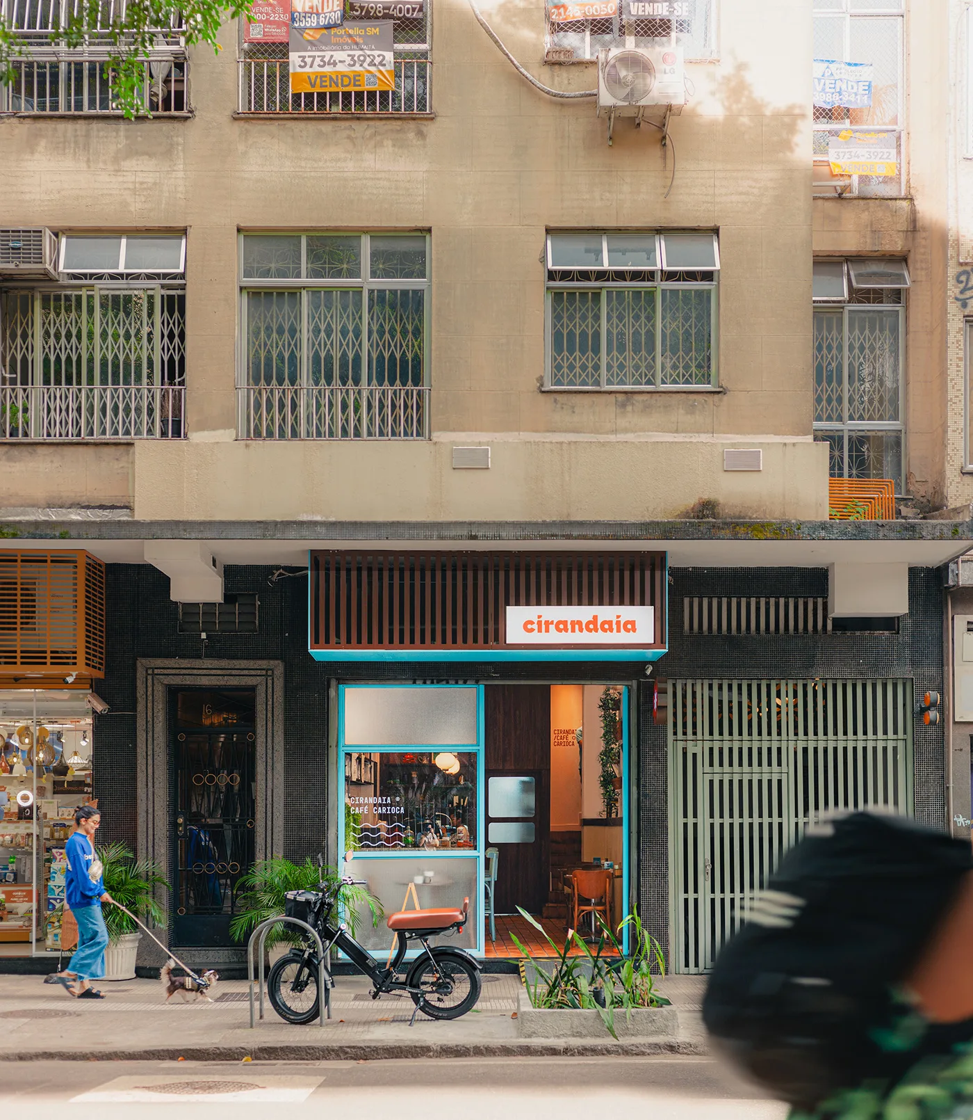 street-level shop with turquoise trim, bicycle parked outside, residential building above., cirandaia, rio de janeiro