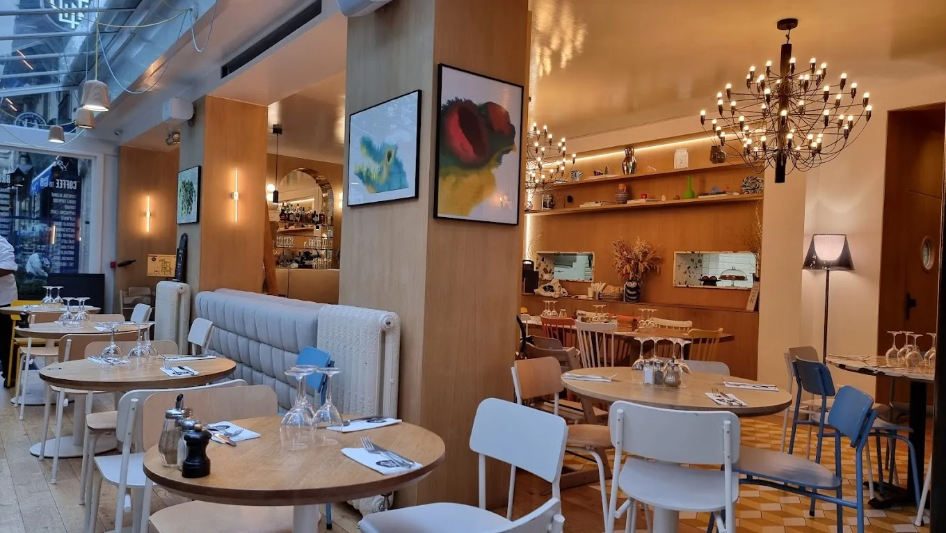 modern restaurant interior with warm lighting, wooden tables, and contemporary artwork on walls., clint gare de lyon, paris