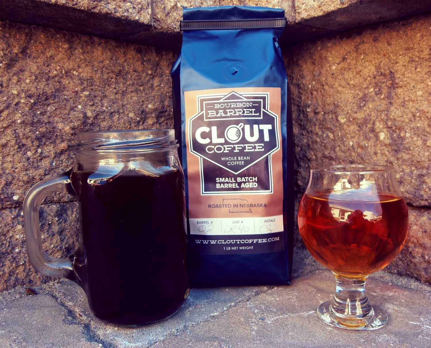 bourbon barrel clout coffee package displayed with freshly brewed coffee and glass., clout coffee, omaha