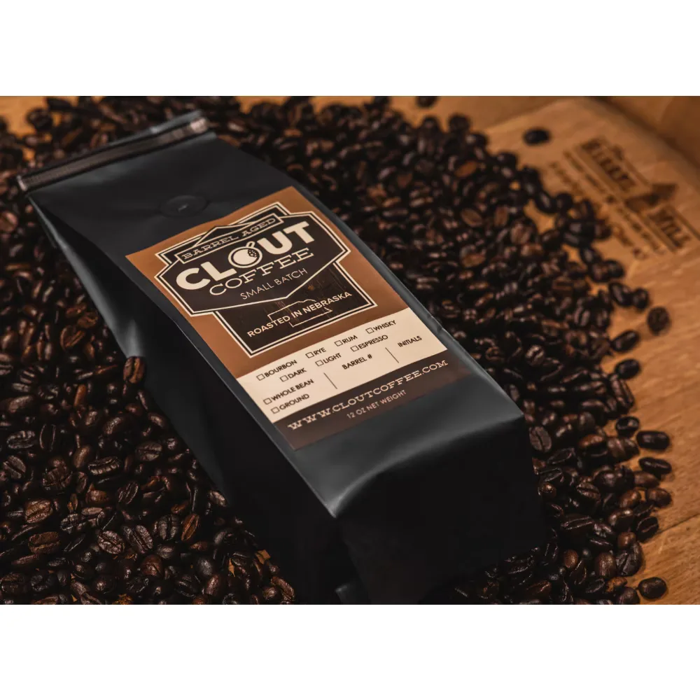clout coffee small batch package surrounded by roasted coffee beans on wooden surface., clout coffee, omaha
