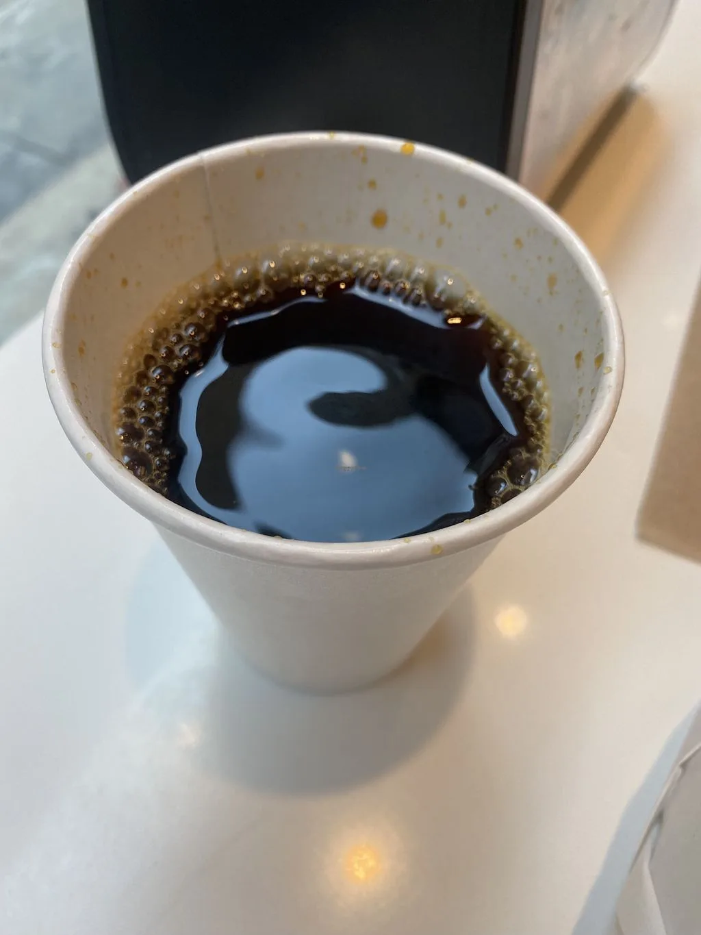 black coffee with crema in white paper cup, overhead view., clover food lab, boston