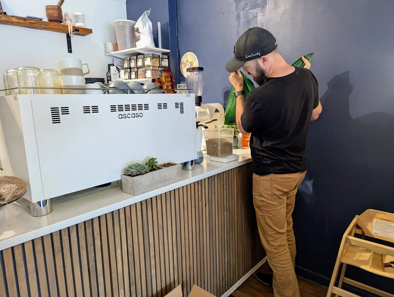 barista in black cap operates ascaso espresso machine at coffee counter., coffee and kindness, nashua