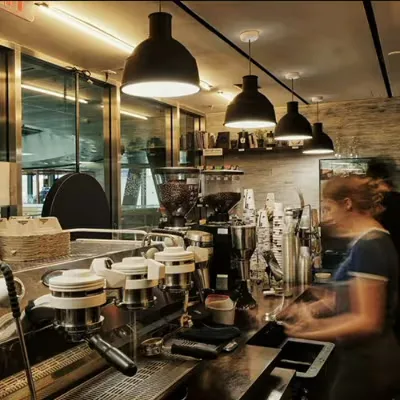professional espresso machine setup with barista working in modern café interior., coffee bros., new york