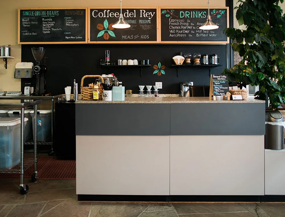 modern coffee shop counter with menu boards, espresso machine, and potted plants., coffee del rey, plano