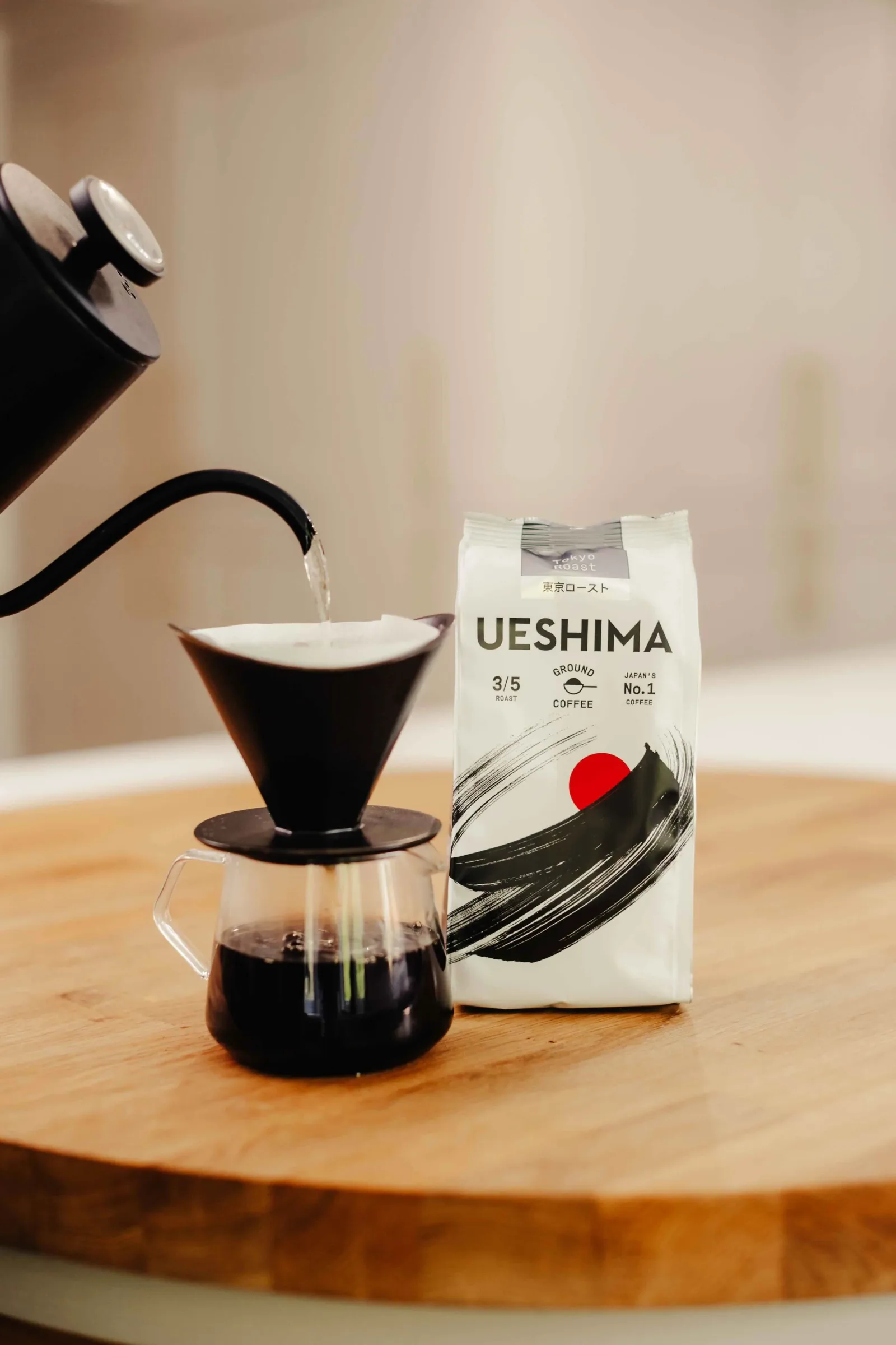 ueshima coffee being poured into black dripper over glass carafe on wooden surface., coffee roast sai, tokyo