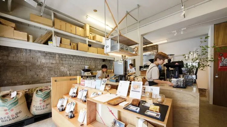 minimalist coffee shop with wooden counters, shelving, and displayed products., coffee wrights kuramae, tokyo