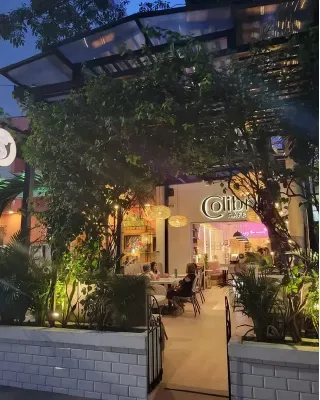 illuminated storefront entrance with climbing vines and warm evening lighting., colibri café, cartagena