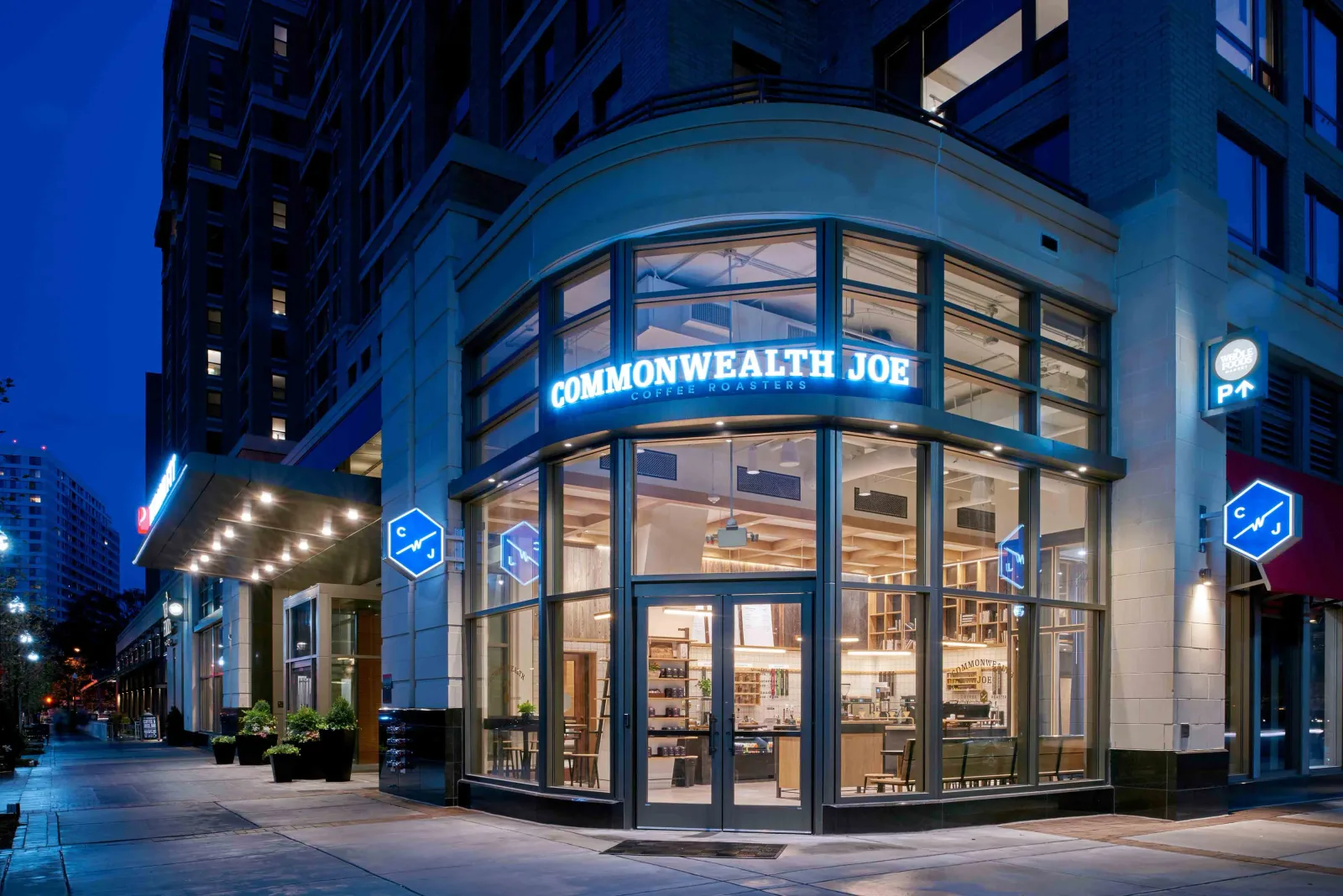 commonwealth joe coffee shop storefront glowing at twilight in urban downtown setting., commonwealth joe coffee roasters, was