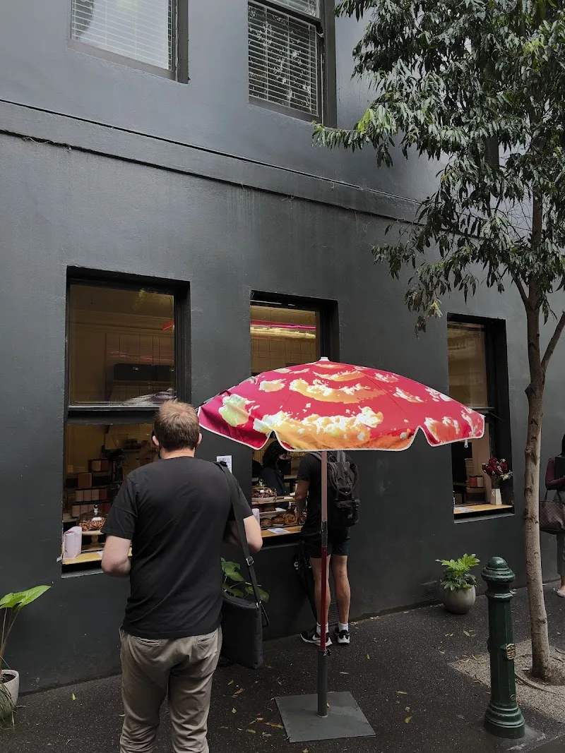 small street food vendor under red umbrella with yellow cloud pattern design., commune, fitzroy